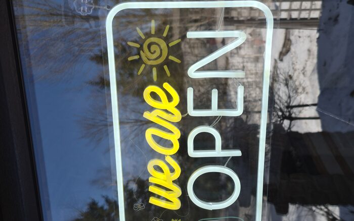 The 'We Are Open' sign at the patio entrance